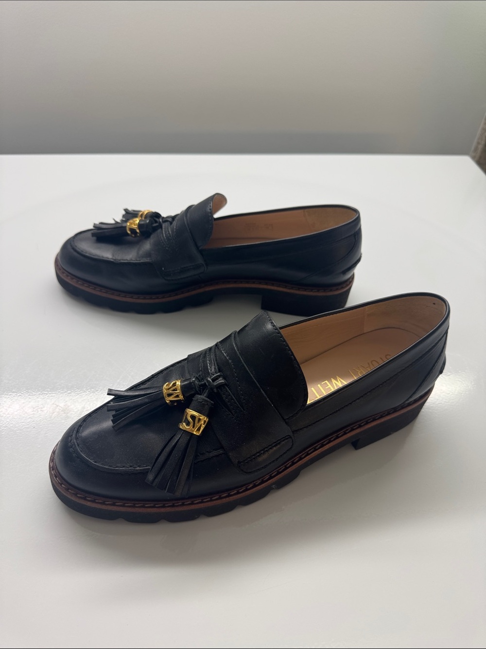 Stuart Weitzman Black Leather Tassel Loafers with Gold Accents